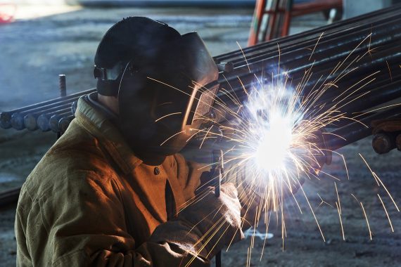worker welding with electric arc electrode